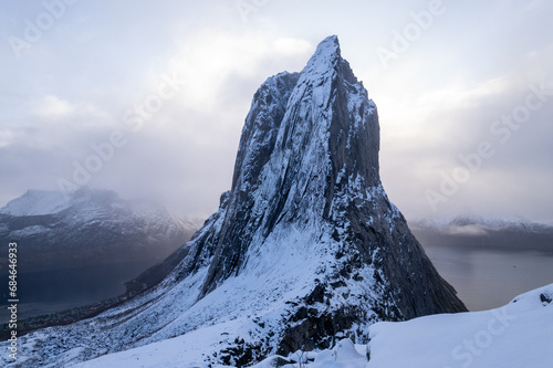 Aerial drone photo of snowy mountain hike up Segla in Senja, Norway. Snowcapped mountains in the Arctic Circle of Northern Norway. Famous hike on Senja island. Shot in October.