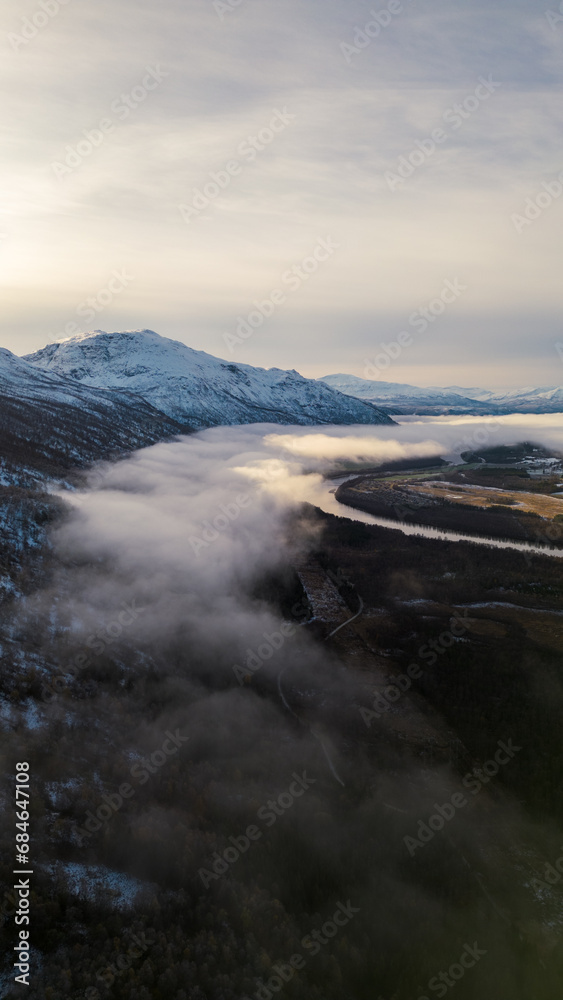 Beautiful aerial of river in Northern Norway with clouds, fog, and mountains. Winding river shot on a drone. Beautiful aerial of river in Northern Norway with clouds, fog, and mountains. Winding river shot on a drone.