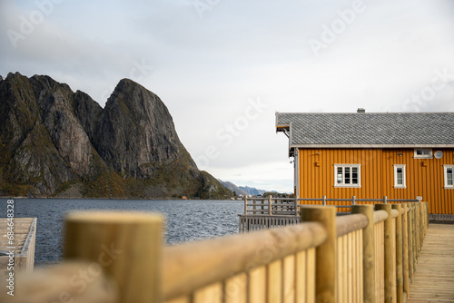 The fishing village of Hamnoy in Lofoten, Norway.  Image shot on a mirrorless camera located in the Arctic circle.  An entire small fishing villlage with yellow houses along the Arctic ocean. photo