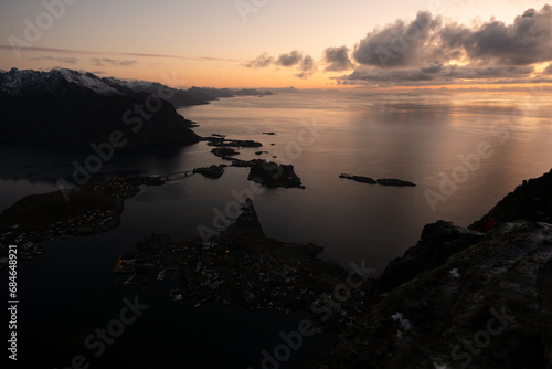 Views from top of Reinebringen mountain hike in Lofoten, Norway.  Snow covered mountains captured on image by a mirrorless camera.  Located far North in the Arctic Circle.  