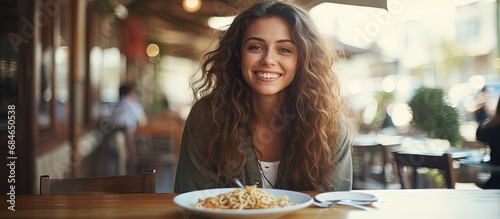 Fototapeta Naklejka Na Ścianę i Meble -  Brunette girl enjoying Italian pasta at a street cafe Advertisements design copy space image