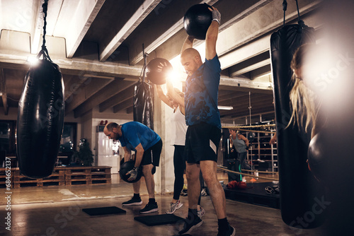 Fit people working out with medicine balls in a boxing gym photo