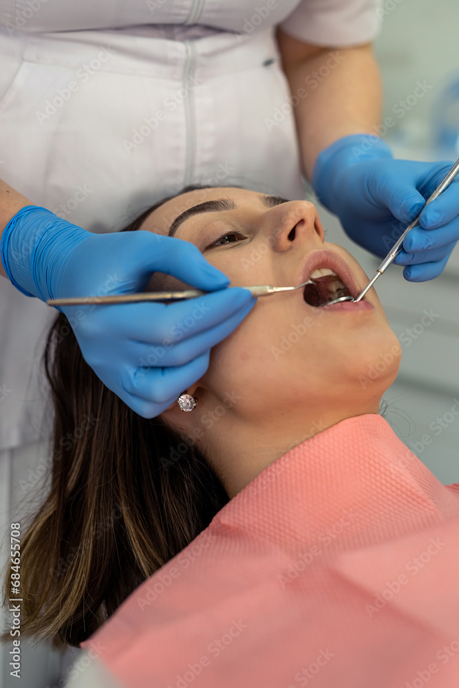 Doctor use dental tools for to check teeth and gums, caries prevention for her female patient Doctor use dental tools for to check teeth and gums, caries prevention for her female patient