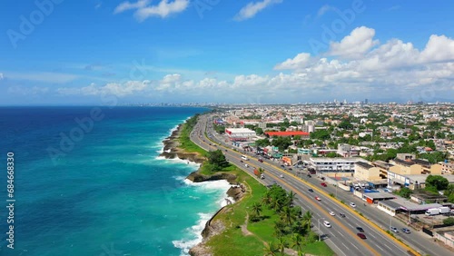 Aerial flight above The Autopista Las Americas along the rocky seacoast. Turquoise caribbean sea and huge waves crashing on the shore. Expressway from the Punta Cana to the Santo Domingo este  photo