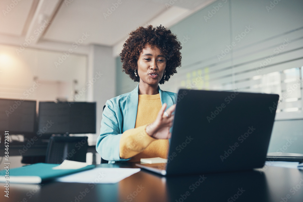 Smiling businesswoman talking during a laptop video call in an office Smiling businesswoman talking during a laptop video call in an office