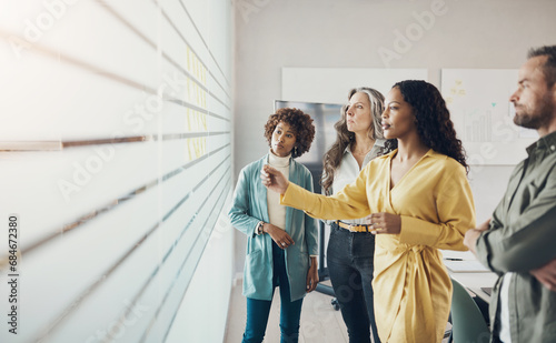 Diverse businesspeople having a brainstorming session with adhesive notes in an office photo