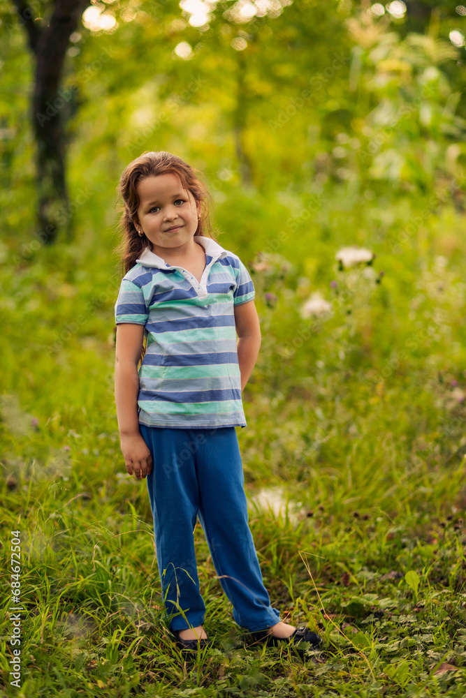 A child stands near a tree in the garden A child stands near a tree in the garden