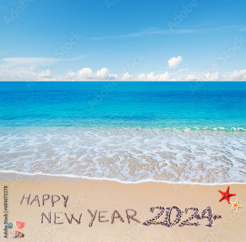 happy new year 2024 written in the sand