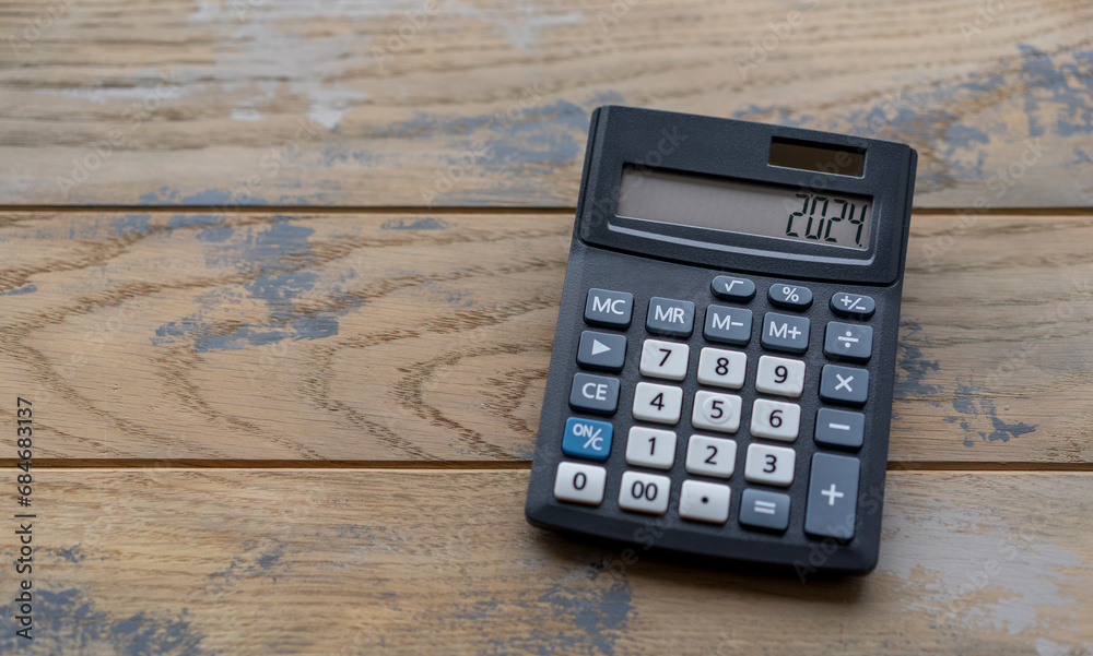 Calculator with the number 2024 on the display. Concept of finance, taxes, savings and economic crisis. Calculator with the number 2024 on the display. Concept of finance, taxes, savings and economic crisis.