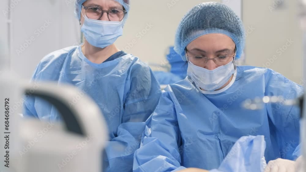A team of surgeons during an operation to remove leg veins using surgical laparoscopy instruments A team of surgeons during an operation to remove leg veins using surgical laparoscopy instruments