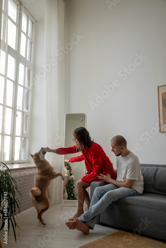 Happy beautiful couple with shiba inu dog at home photo