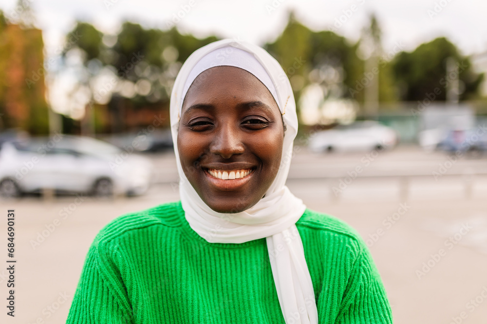 Portrait of young black muslim woman wearing hijab smiling at camera outdoors. Diversity and islam concept. Portrait of young black muslim woman wearing hijab smiling at camera outdoors. Diversity and islam concept.