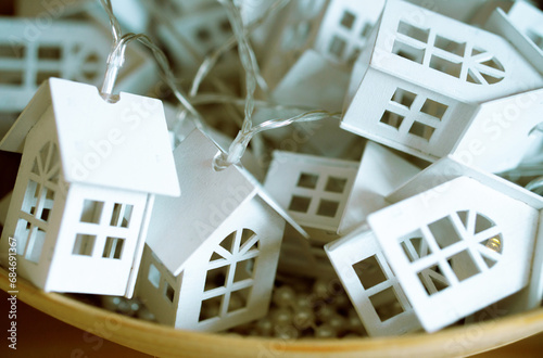 Christmas garland in the form of white houses in the basket. Close up lot of toy white houses in bsket photo