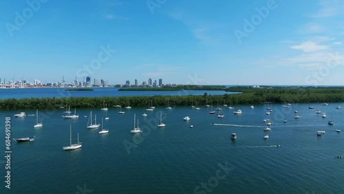 Aerial view of Rickenbacker Marina full of yachts and sailboats with Miami real estate on horizon. Wonderful place for watersports activities near green islets in Biscayne Bay photo