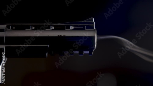 Smoking gun scene side view - silver crhome barrel - close up - in slow motion with dark background