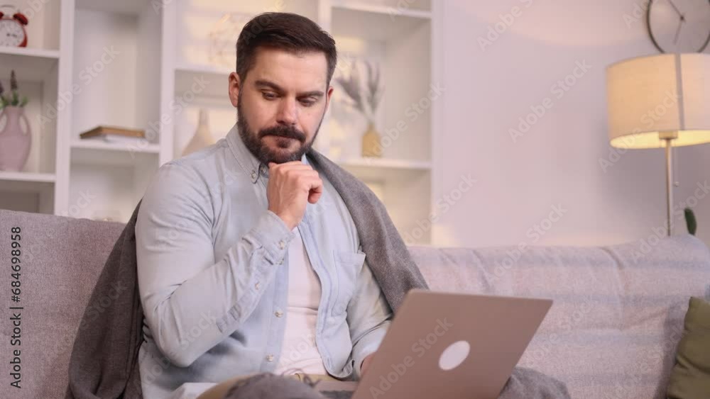 Positive mature man thinks questioningly imagine plan in mind has doubts create idea and looking at screen while finding solution idea next to laptop with happy inspired face on couch at home