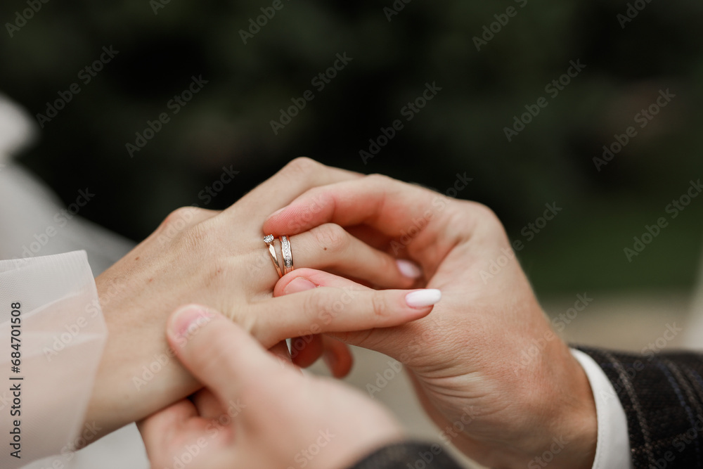 wedding rings on the hands of the newlyweds at the wedding wedding rings on the hands of the newlyweds at the wedding