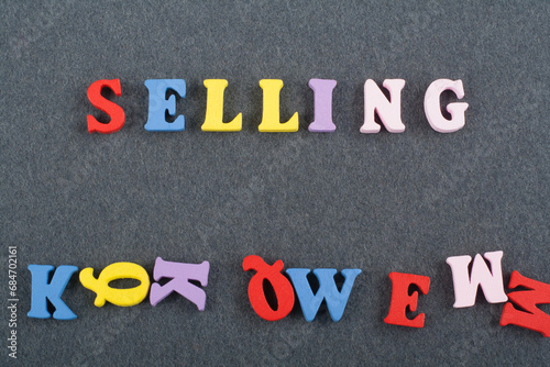 SELLING word on black board background composed from colorful abc alphabet block wooden letters, copy space for ad text. Learning english concept. photo