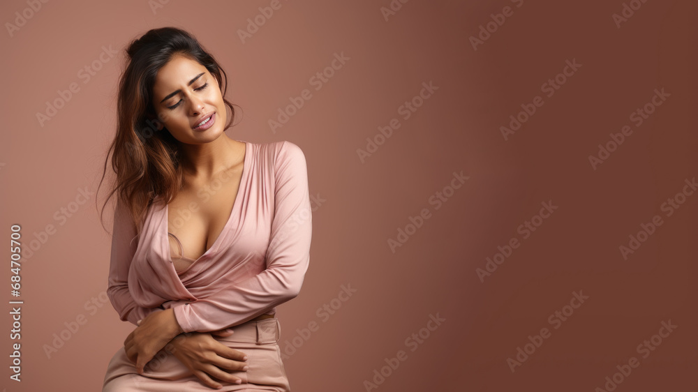 Indian woman wincing in pain and hand rubbing stomach