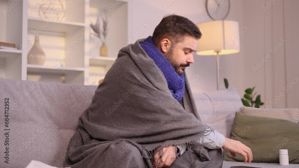 Sick man under the blanket coughing sneezing having severe headache temperature when mentioned useful medical app service or site at home Help service concept Sick man under the blanket coughing sneezing having severe headache temperature when mentioned useful medical app service or site at home Help service concept