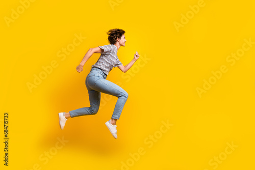 Full length profile portrait of excited energetic person jump rush empty space isolated on yellow color background