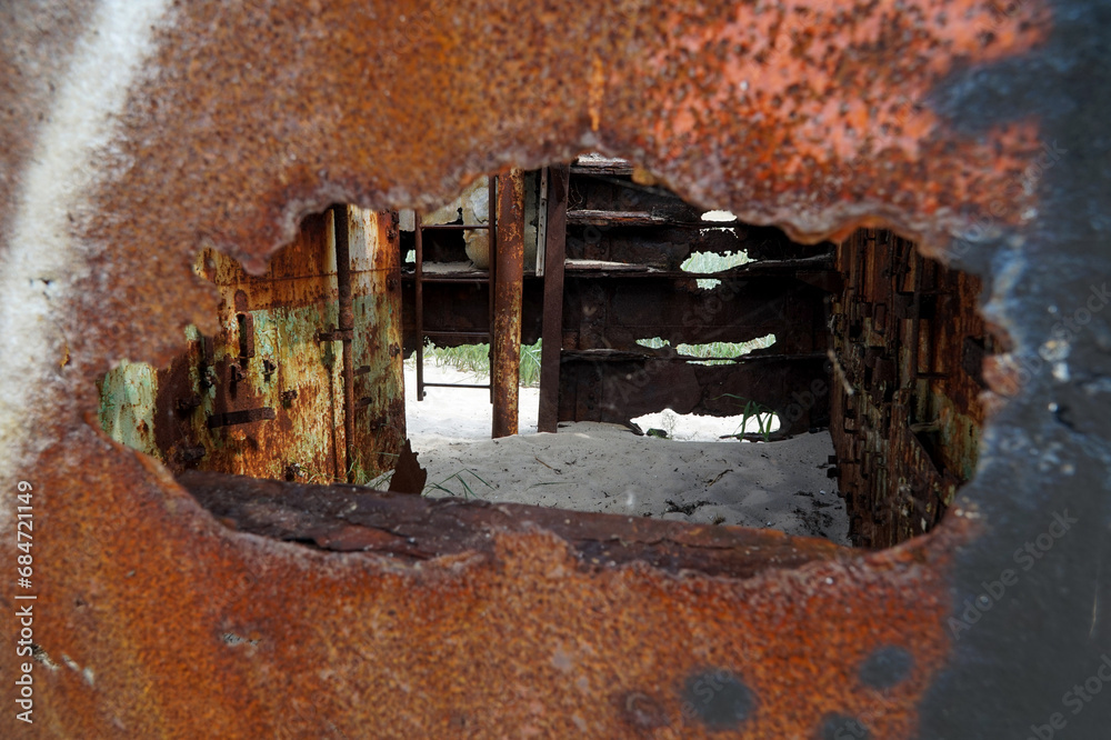 An abandoned rusty warship on the sand of the Baltic Sea. Hel.