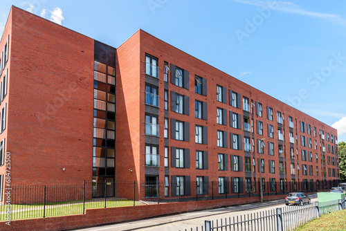 Exterior of a large new apartment building along a street on a sunny day photo