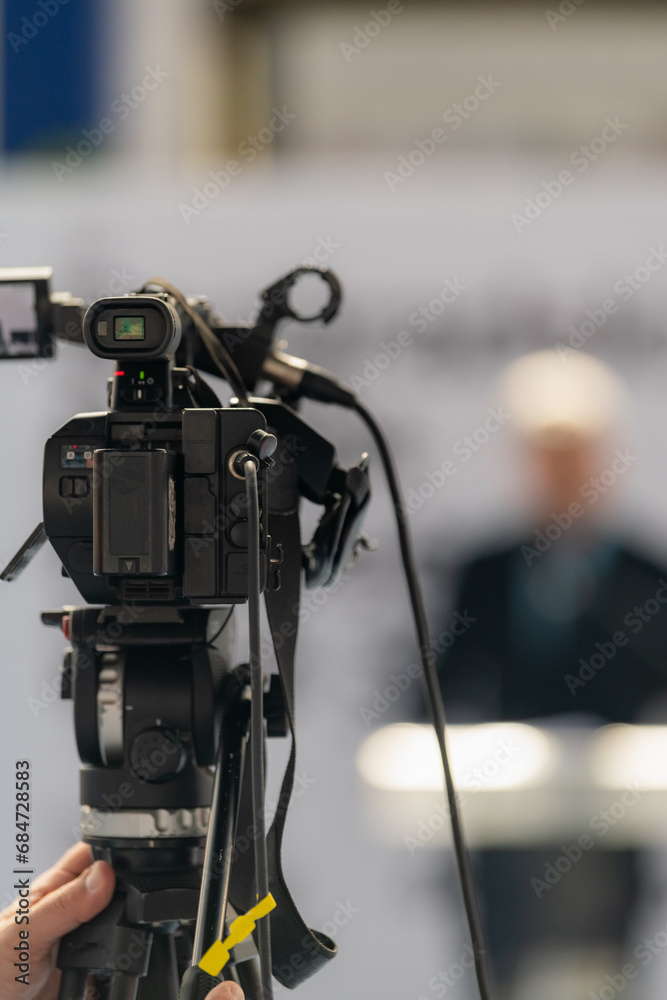 TV camera records a compelling male speaker on stage, delivering impactful insights on fair TV camera records a compelling male speaker on stage, delivering impactful insights on fair