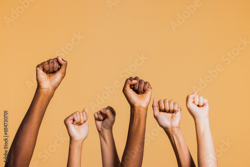Hands raised with closed fists. Diverse coloured hands raised up with closed fist symbolizing power, determination. photo