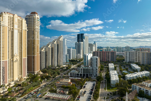 Expensive highrise hotels and condos on Atlantic ocean shore in Sunny Isles Beach city and busy street traffic. American tourism infrastructure in southern Florida