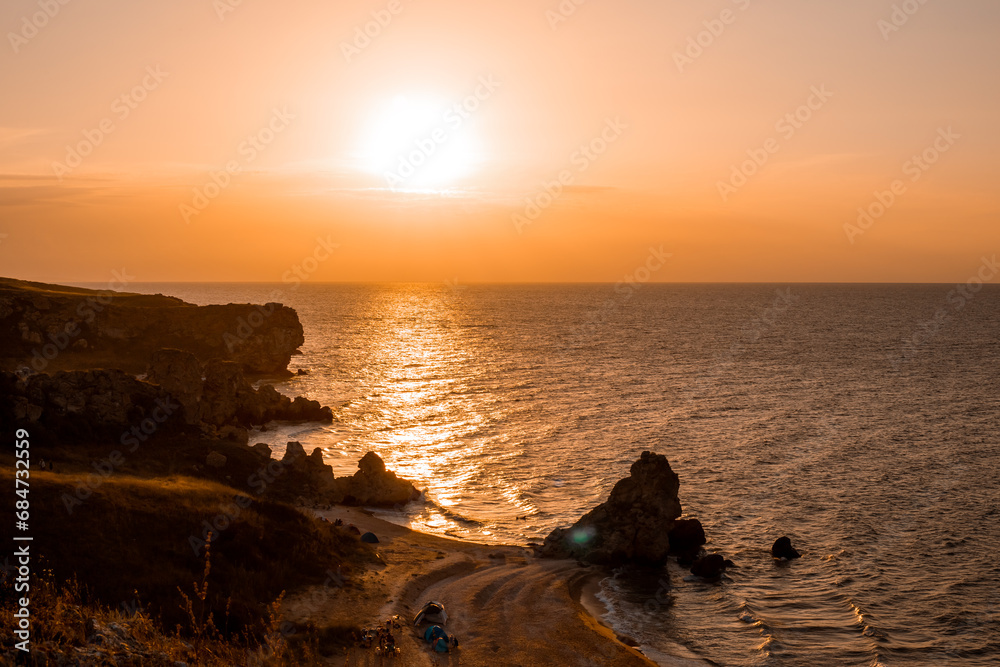 Seascape. View from the mountain to the sea with the beach and cliffs at sunset
