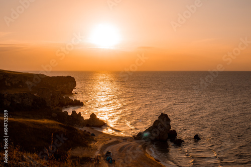 Seascape. View from the mountain to the sea with the beach and cliffs at sunset
