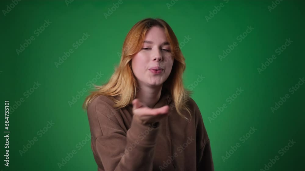 Smiling Woman Blowing Air Kiss on Green Background Smiling Woman Blowing Air Kiss on Green Background