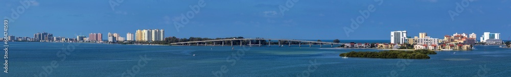 Sand Key Bridge - A panoramic view of Sand Key Bridge, connecting Clearwater at right and Belleair Beach at left, over the Clearwater Pass on a calm Autumn morning, Florida, USA. Sand Key Bridge - A panoramic view of Sand Key Bridge, connecting Clearwater at right and Belleair Beach at left, over the Clearwater Pass on a calm Autumn morning, Florida, USA.