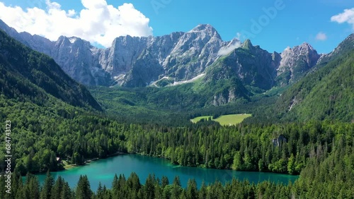 Picturesque lake Lago Fusine in Italy. Fusine lake with Mangart peak on background. Popular travel destination of Julian Alps. Location: Tarvisio comune , Province of Udine, Italy, Europe. photo
