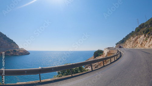 View from a car along a winding coast. Cliffs to the right  sea to the left. View from the first side of the driver towards the sea. Journey by car.