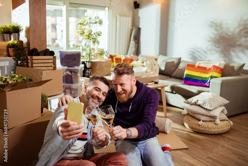 Gay couple joyfully captures their moving in moment with a selfie