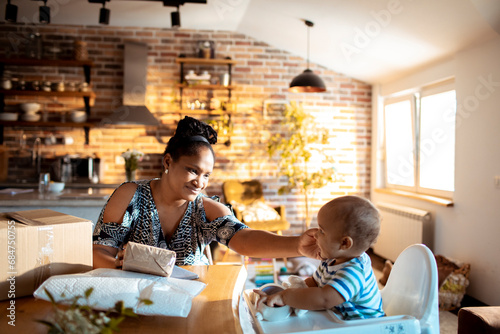 Woman holding package with baby at home photo