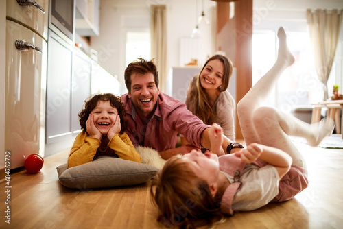 Joyful family playing together on the floor at home