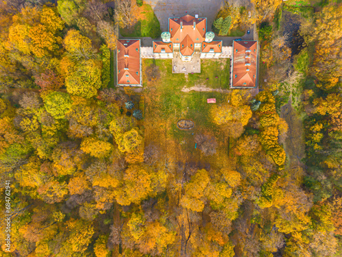 Aaerial view on the beautiful palace in Autumn sunset. White palace in the autumn forest. High altitude. photo