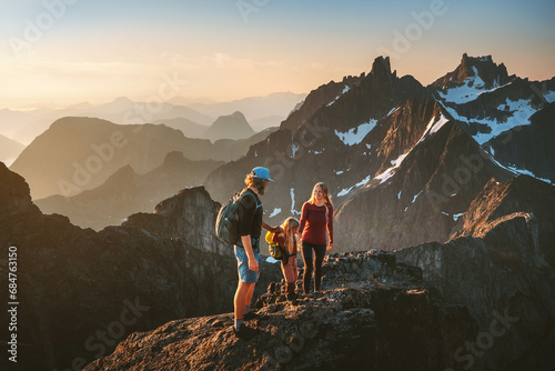 Family hiking together travel in Norway mountains: parents and child outdoor climbing adventure healthy lifestyle outdoor active vacations mother and father with kid trekking photo