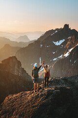 Couple climbing mountains together success concept romantic vacations in Norway man and woman outdoor family travel lifestyle sustainable tourism sunset landscape