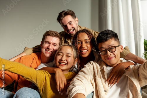 multiracial group of young friends smiling and taking selfies for the camera, asian, african american and european photo