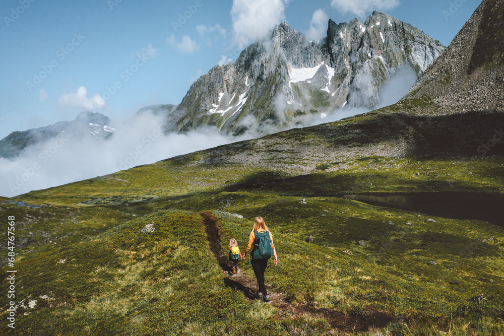 Family adventure in the mountains of Norway, mother with daughter backpacking outdoor hiking journey together enjoying active vacations and wilderness landscape