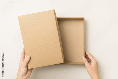 woman opens empty kraft cardboard box, top view. delivery and packaging concept © Iryna_B