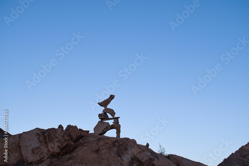 sculptures made from rocks with birds on top of them, in the middle of nowhere