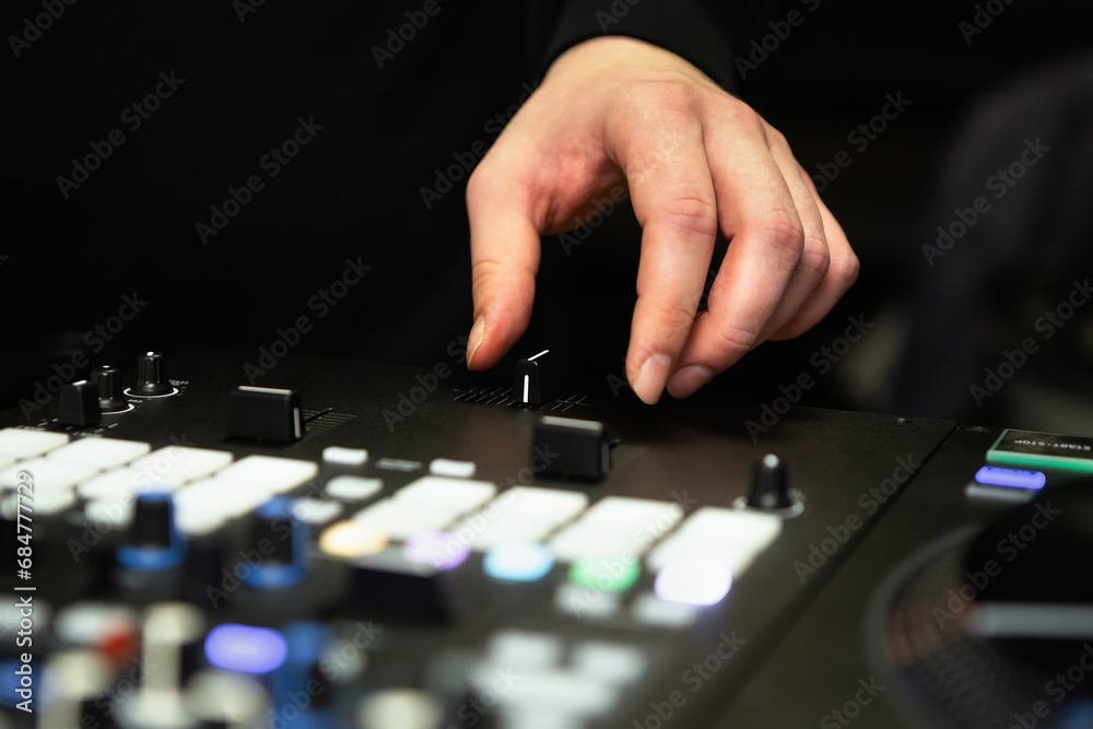 DJ using cross fader on a sound mixer to scratch vinyl records on a hip hop party DJ using cross fader on a sound mixer to scratch vinyl records on a hip hop party