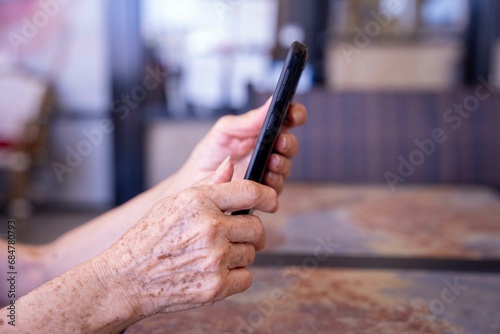 Profile of senior female hands holding a smartphone.