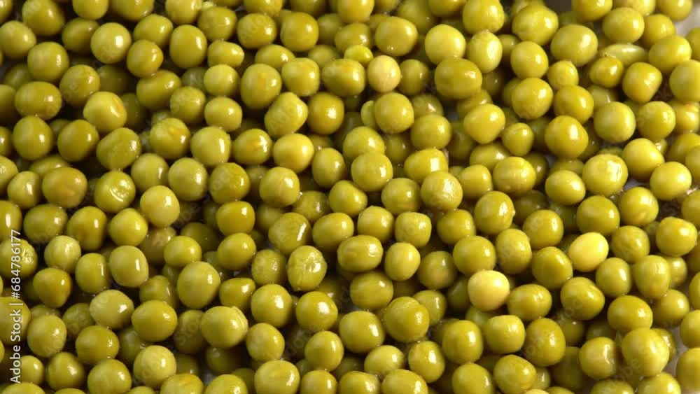 Canned green pea kernels background rotate top view. Marinated pickled sweet green peas Canned green pea kernels background rotate top view. Marinated pickled sweet green peas