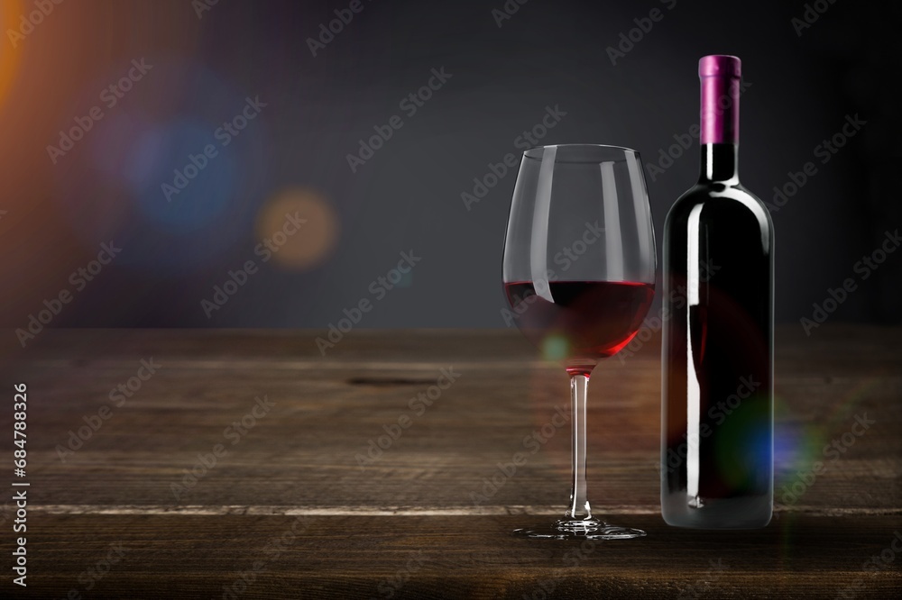 Bottle of wine and glass on wooden table.